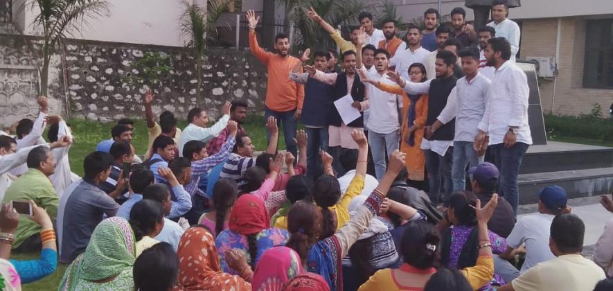 कर्मचारियों के समर्थन में धरना-प्रदर्शन करते छात्र
