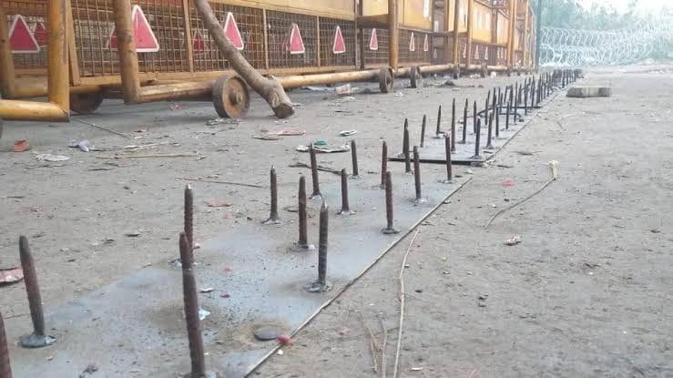कंटीले तार लम्बी नुकीले कीलों के घेरे में लोकतंत्र