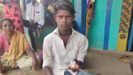 चंद्राबाई थानेकर का 16 वर्षीय बेटा रमेश उनकी फोटो को हाथ में लिए हुए।